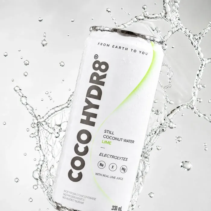 A can of COCO HYDR8 Lime tilted in a crown of splashing water
