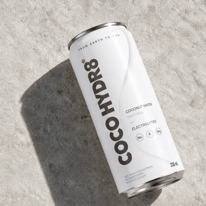 A can of COCO HYDR8 Natural lying on warm stone in hard afternoon light